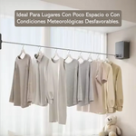 Ropa colgada en tendedero retráctil de pared en hogar ordenado